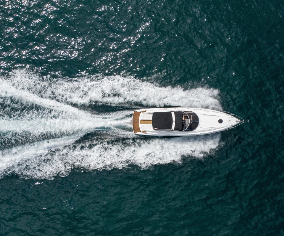 Motor yacht seen from above while crossing dark ocean water