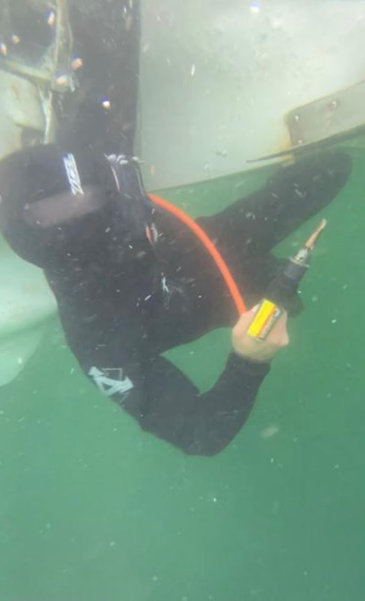 Diver working on the underside of a boat